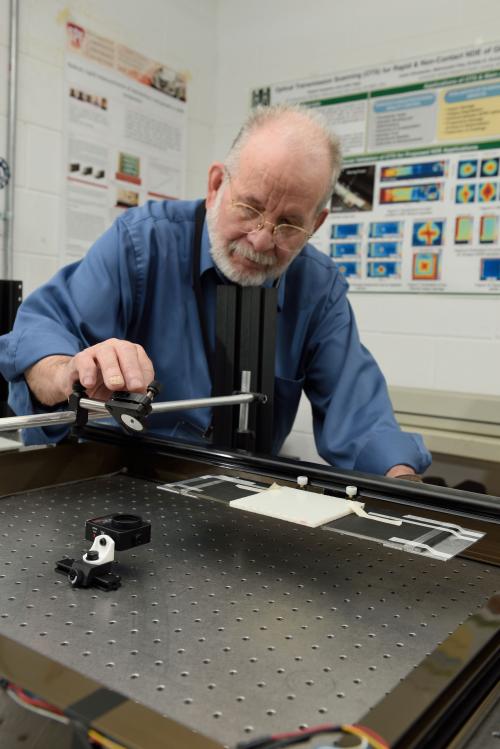 Photo of Gary Cloud demonstrating the optical equipment