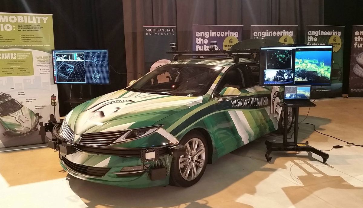 MSU Connected and Autonomous Vehicle Lab setup with green wrapped vehicle and sensor displays